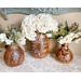 These are three finished gourd vases with faux flower arrangements. The artwork includes a sunflower and butterfly artwork on the front.